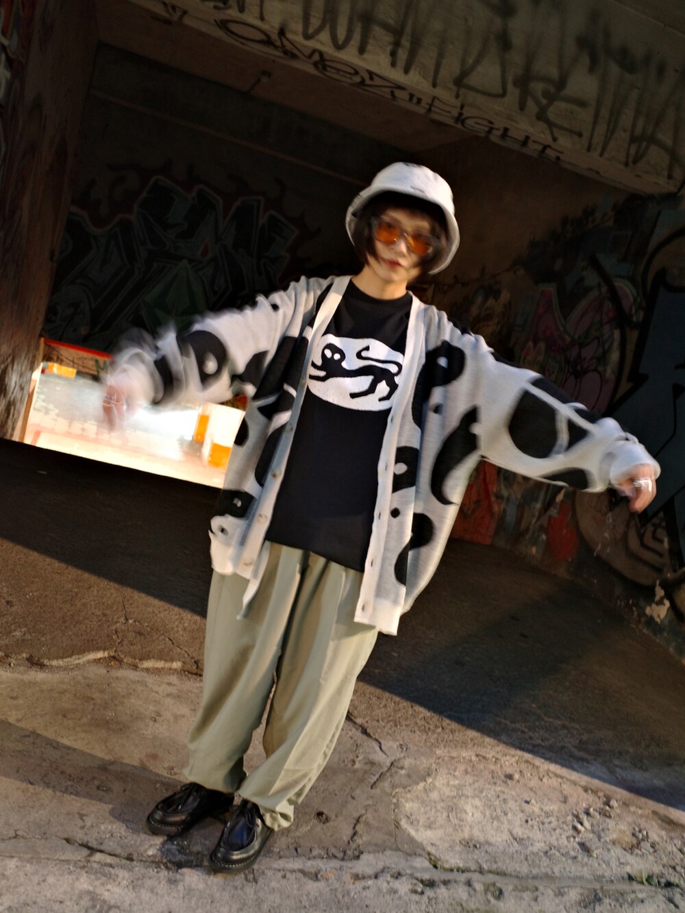 グレー系のニット/セーター、グリーン系のスラックス、ブラック系のシューズを着用したレディースの夏コーディネートの4枚目の写真