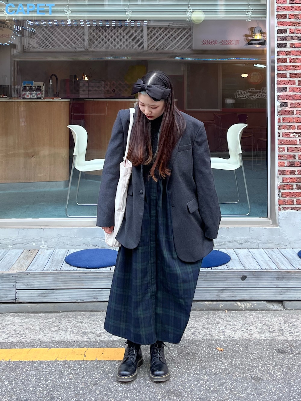 グリーン系のシャツワンピース、ブラック系のブーツを着用したレディースの秋コーディネートの2枚目の写真