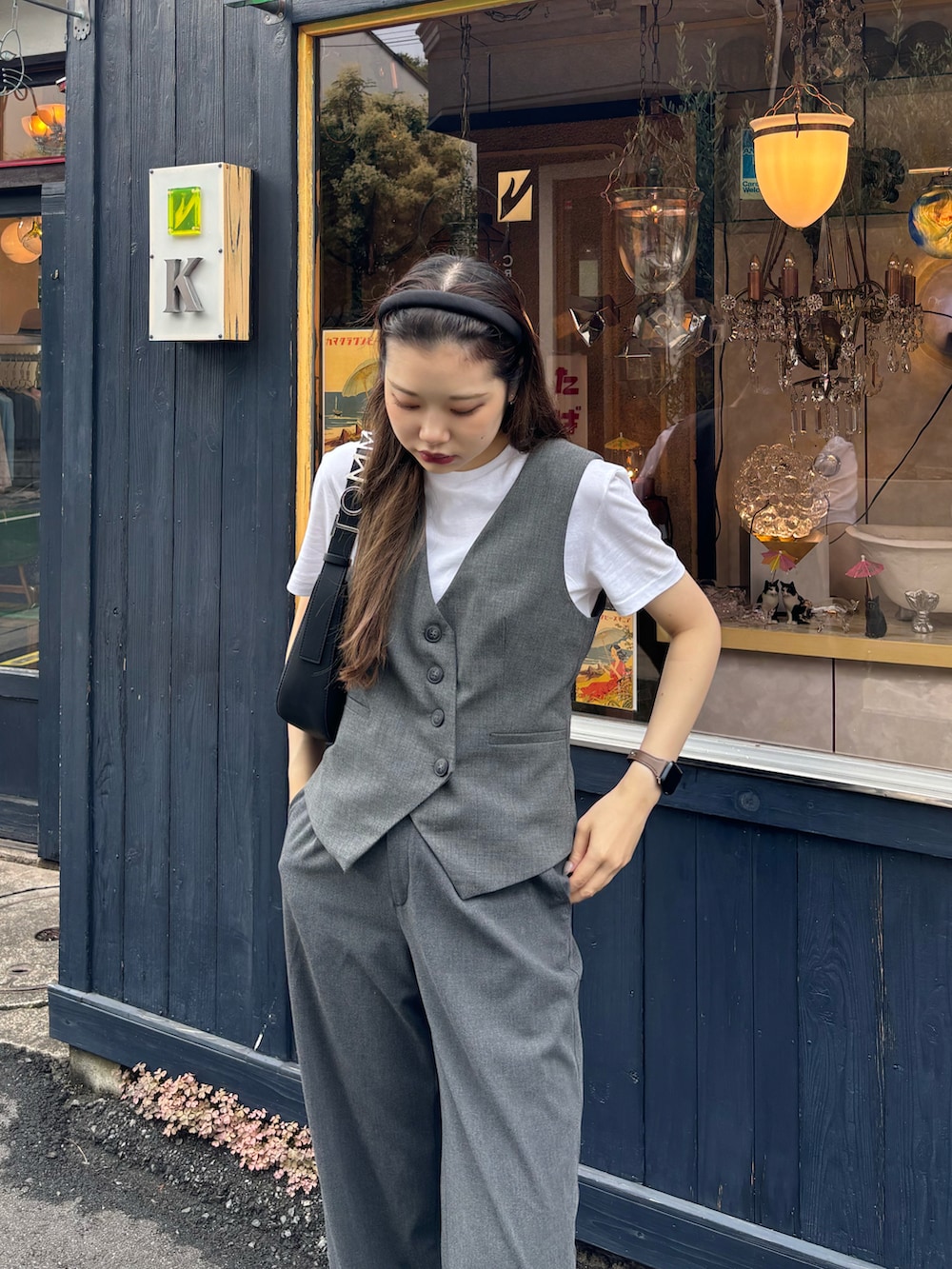 ブラック系のスラックス、ブラック系のブーツ、ホワイト系のTシャツ/カットソーを着用したレディースの夏コーディネートの2枚目の写真