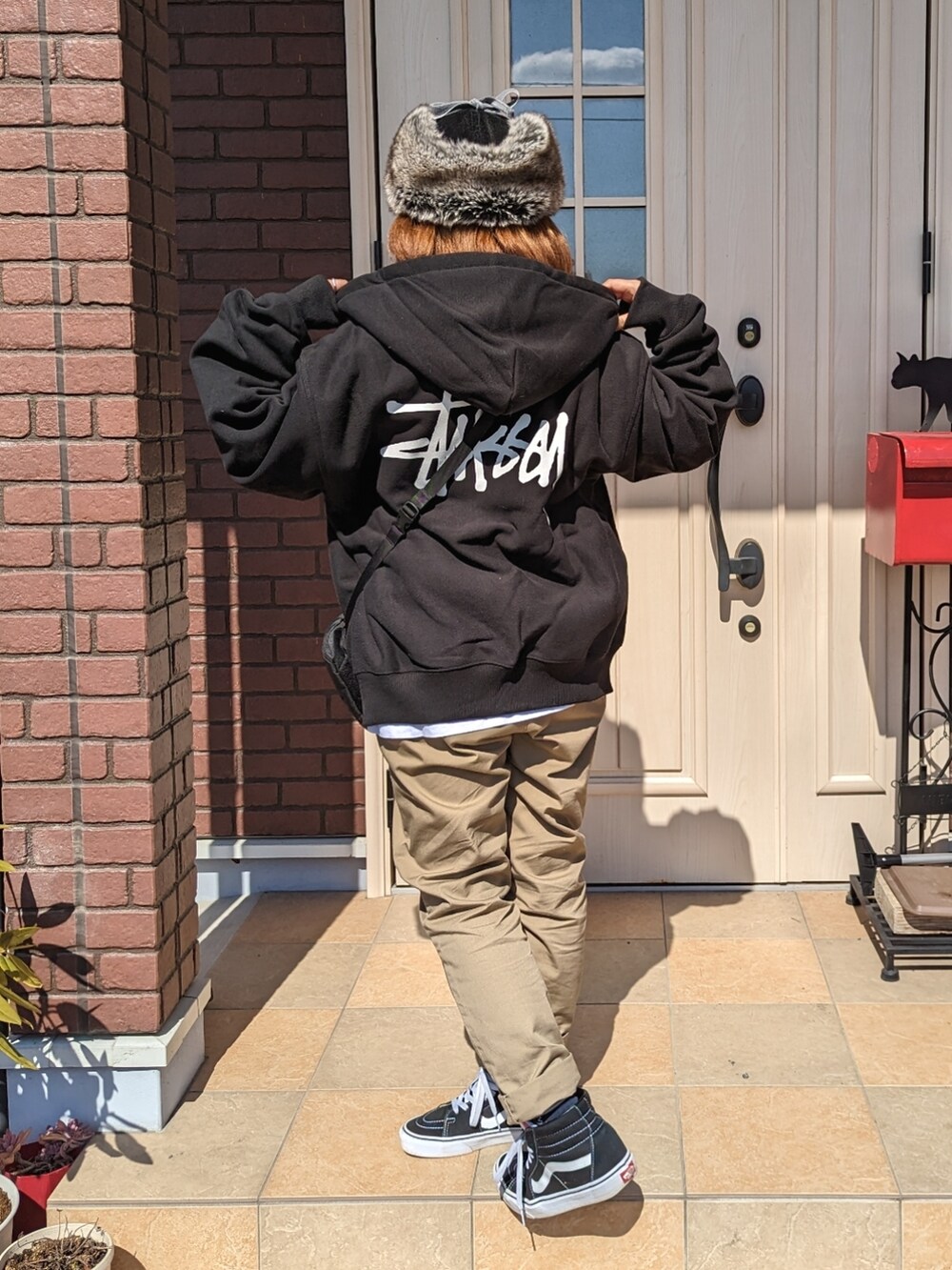 ブラック系のパーカー、ホワイト系のTシャツ/カットソー、ブラック系のボディバッグ/ウエストポーチを着用したレディースの春コーディネートの2枚目の写真