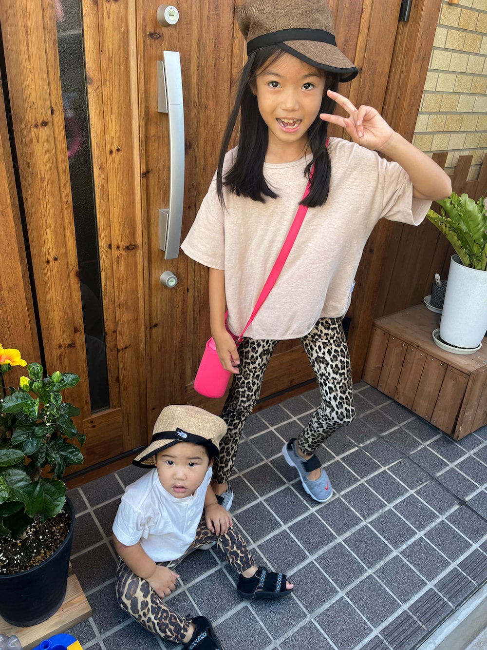 ピンク系のTシャツ/カットソー、グレー系のサンダル、ブラウン系のキャップを着用したキッズの夏コーディネートの2枚目の写真