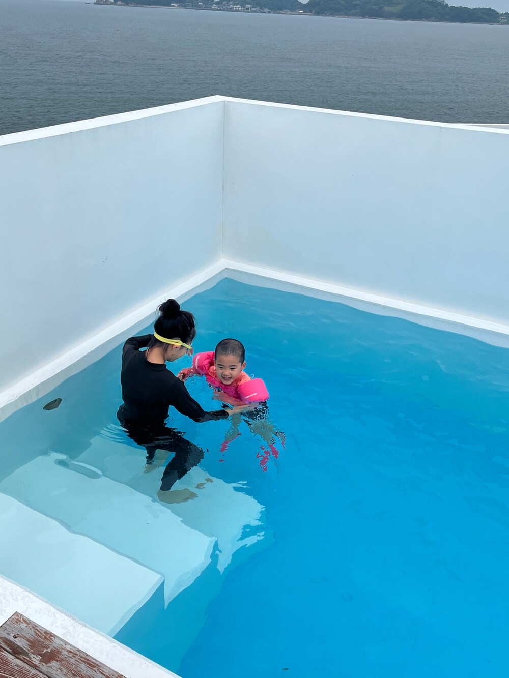 ブラック系のTシャツ/カットソー、ブラック系のパンツ、ピンク系のサンダルを着用したキッズの夏コーディネートの3枚目の写真