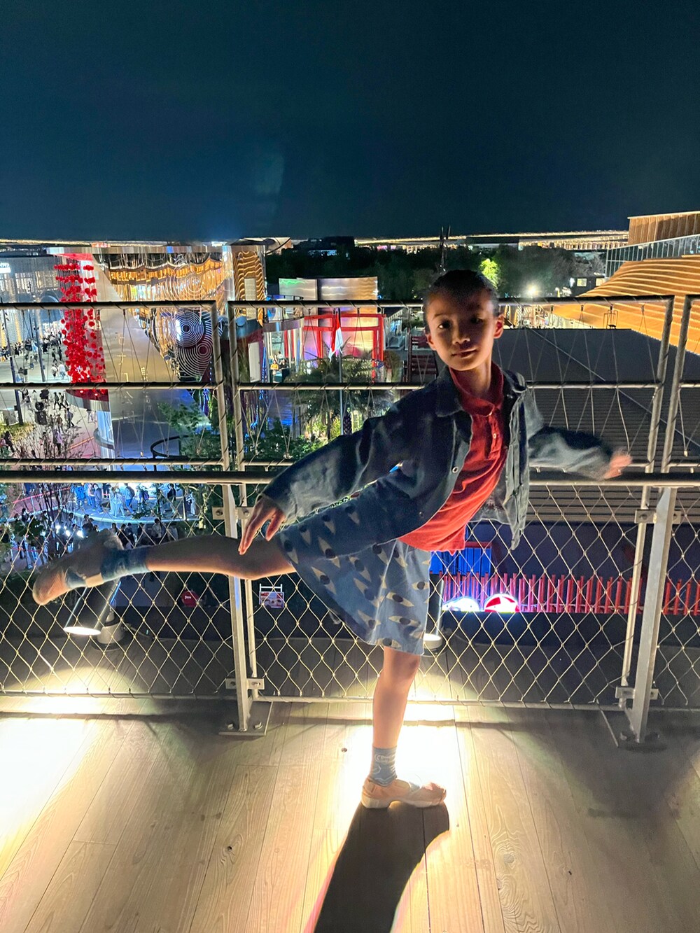 レッド系のポロシャツ、ブルー系のスカート、ピンク系のスニーカーを着用したキッズの夏コーディネートの4枚目の写真