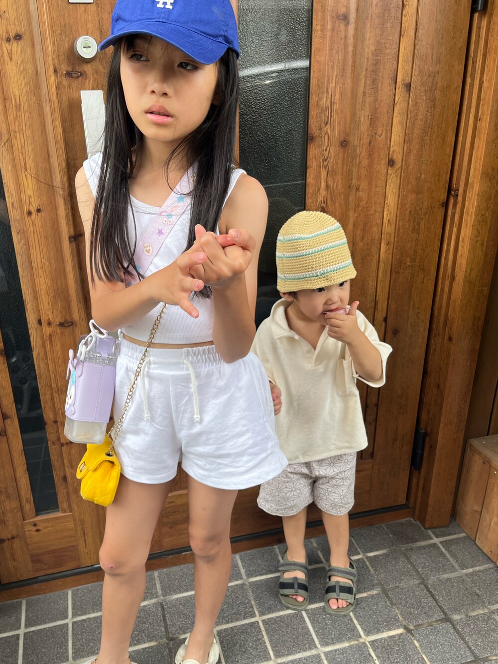 ホワイト系のタンクトップ、ホワイト系のスウェットパンツ、ホワイト系のサンダルを着用したキッズの夏コーディネートの3枚目の写真