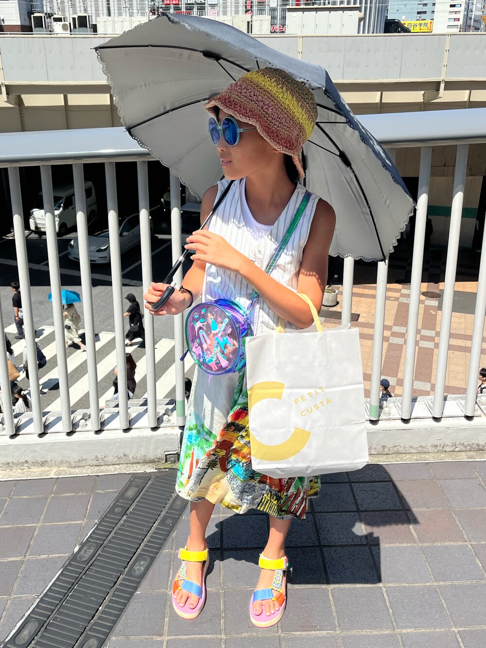 ピンク系のサンダル、ホワイト系のベスト、ブルー系のスカートを着用したキッズの夏コーディネートの2枚目の写真