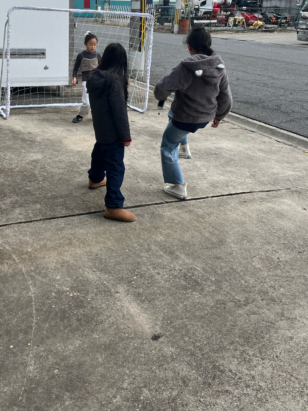 グレー系のスウェットパンツ、グレー系のトップス、ピンク系のナイロンジャケットを着用したキッズの冬コーディネートの4枚目の写真