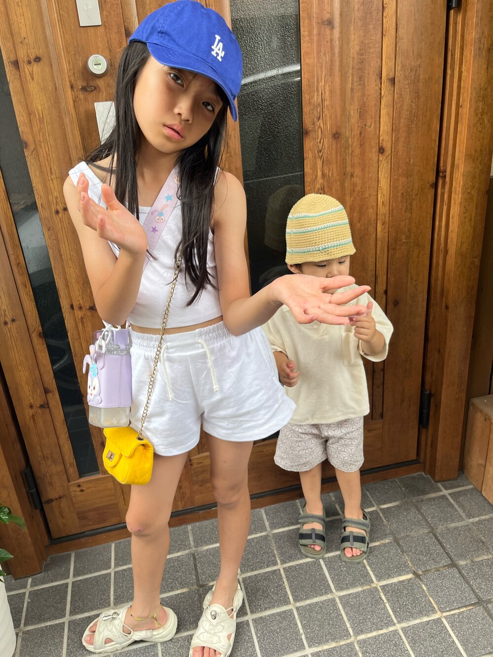 ホワイト系のタンクトップ、ホワイト系のスウェットパンツ、ホワイト系のサンダルを着用したキッズの夏コーディネートの2枚目の写真