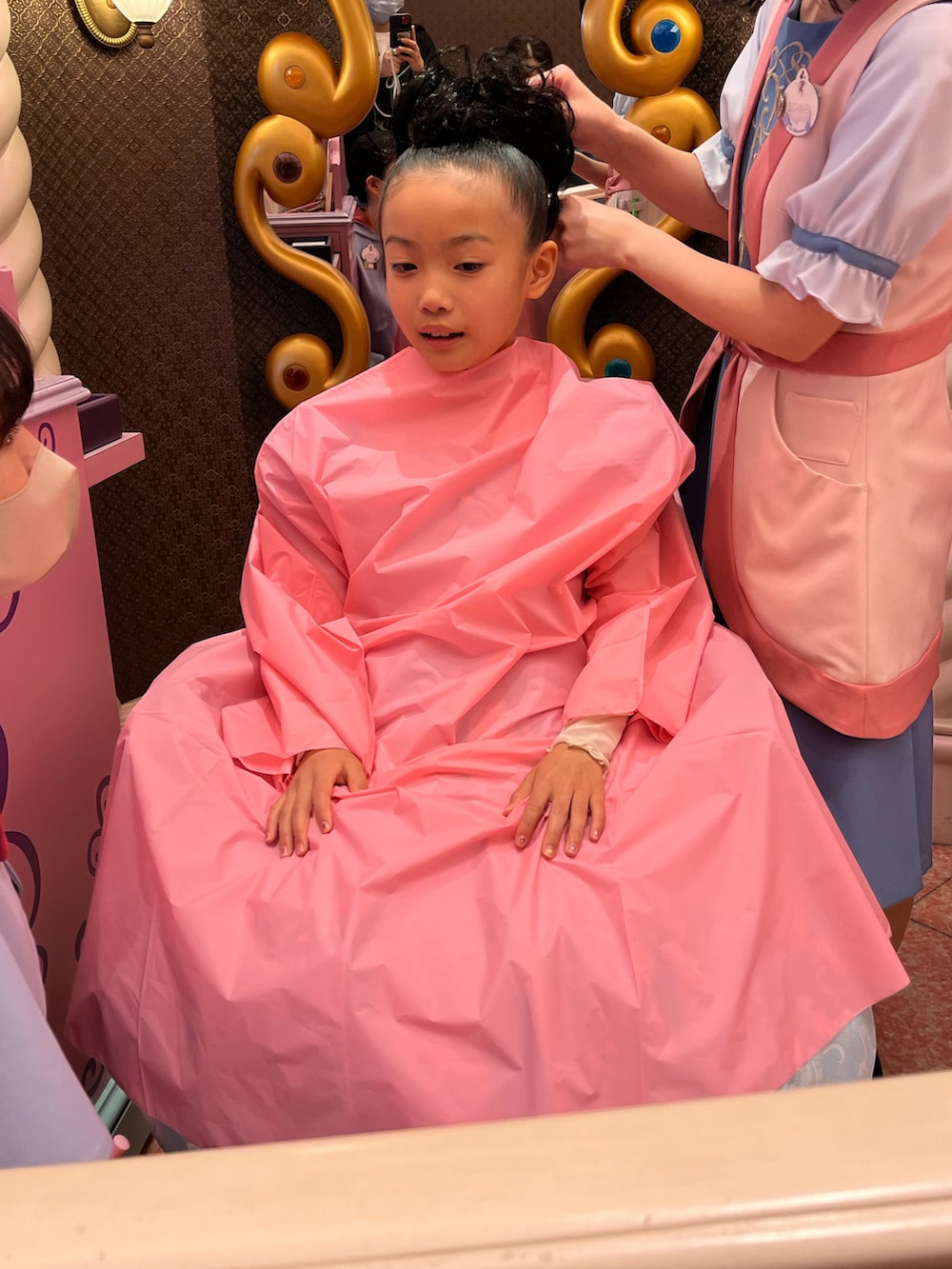 ピンク系のワンピース、ベージュ系のスリッポン、ブラウン系のベストを着用したキッズの春コーディネートの4枚目の写真