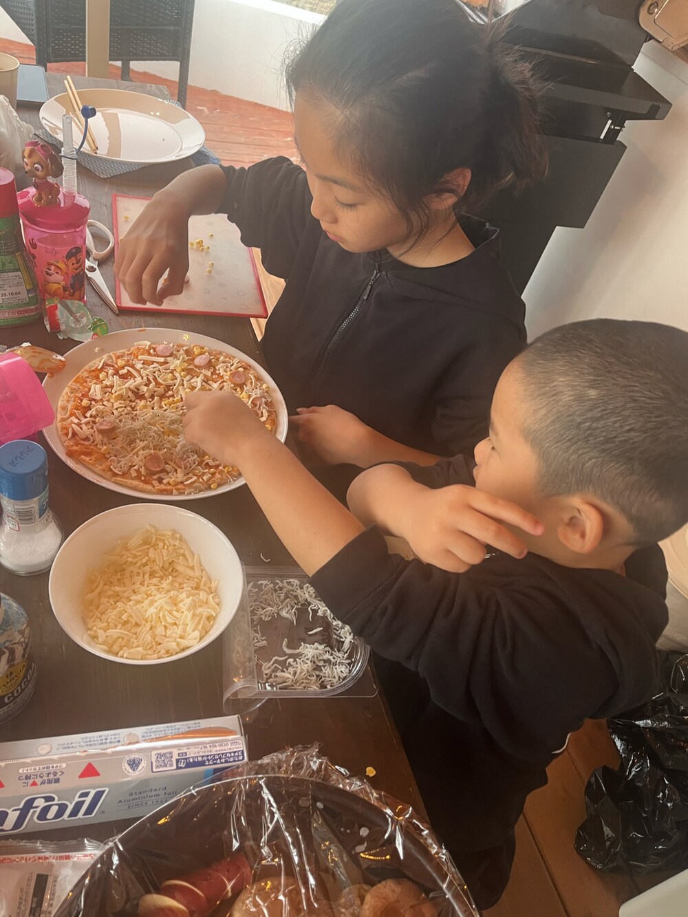 ブラック系のTシャツ/カットソー、ブラック系のパンツ、ピンク系のサンダルを着用したキッズの夏コーディネートの4枚目の写真