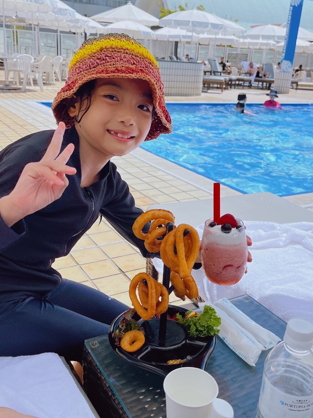 ベージュ系のハット、ブルー系の水着、ブラック系のラッシュガードを着用したキッズの夏コーディネートの2枚目の写真