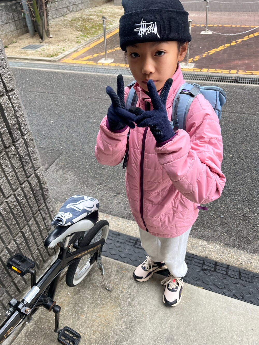 グレー系のスウェットパンツ、グレー系のトップス、ピンク系のナイロンジャケットを着用したキッズの冬コーディネートの2枚目の写真