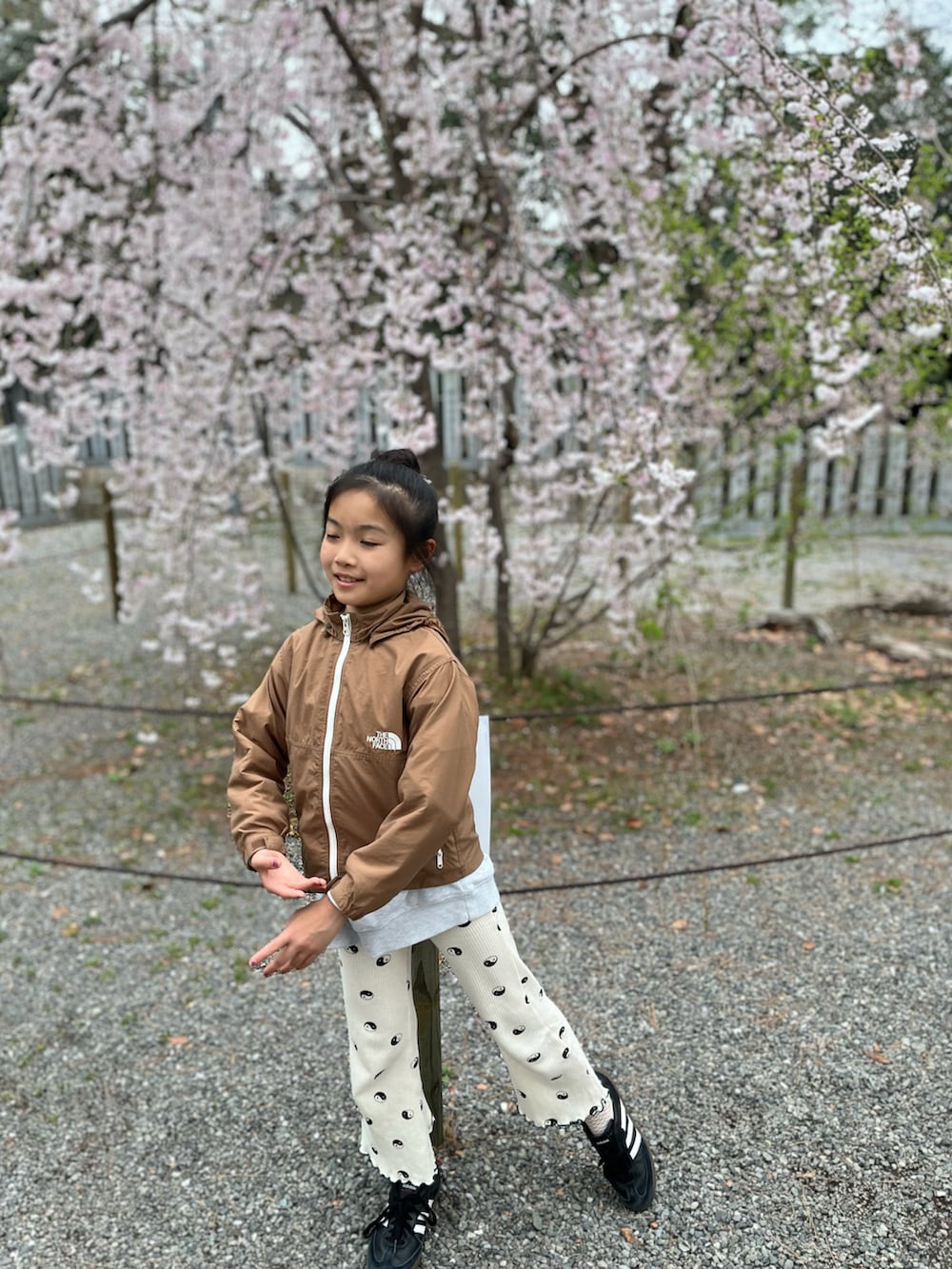 グレー系のスウェット、ブラウン系のナイロンジャケット、ホワイト系のその他パンツを着用したキッズの春コーディネートの3枚目の写真