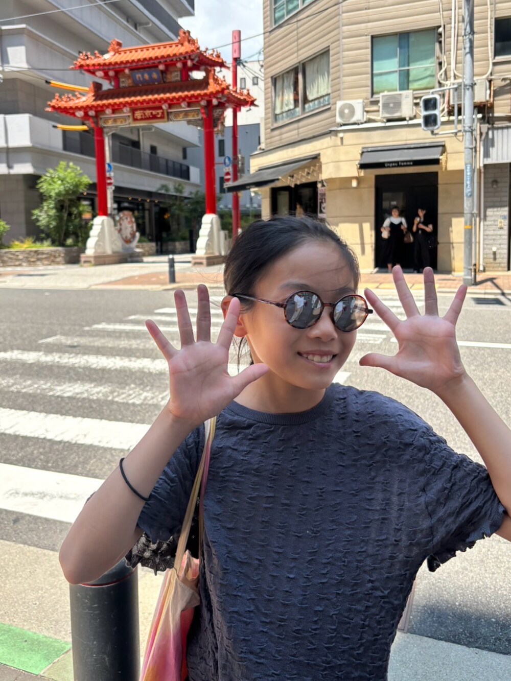 ピンク系のサンダル、グレー系のトップス、グレー系のパンツを着用したキッズの夏コーディネートの2枚目の写真