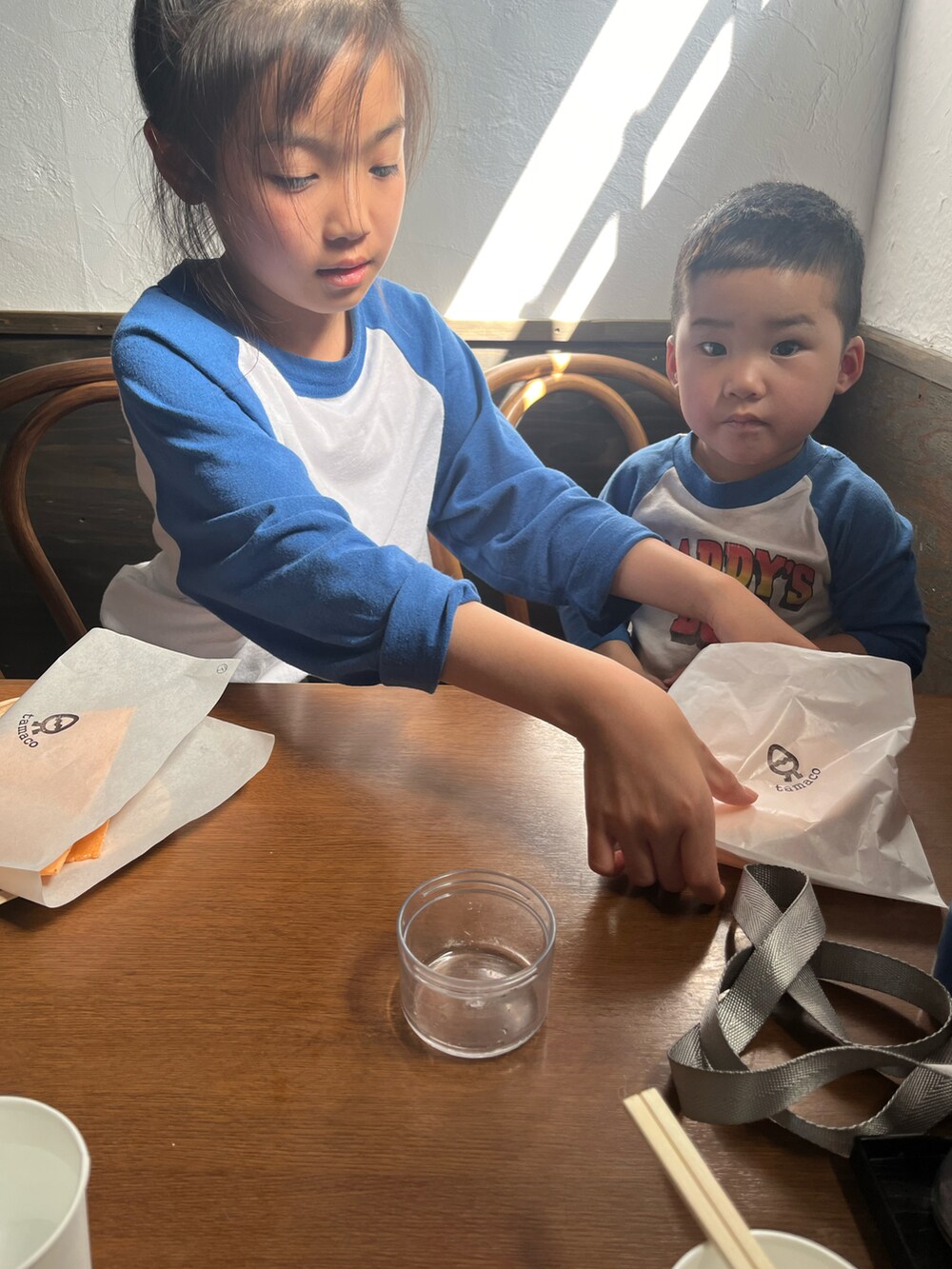 グリーン系のチノパンツ、ホワイト系のTシャツ/カットソー、ブラック系のスリッポンを着用したキッズの春コーディネートの2枚目の写真