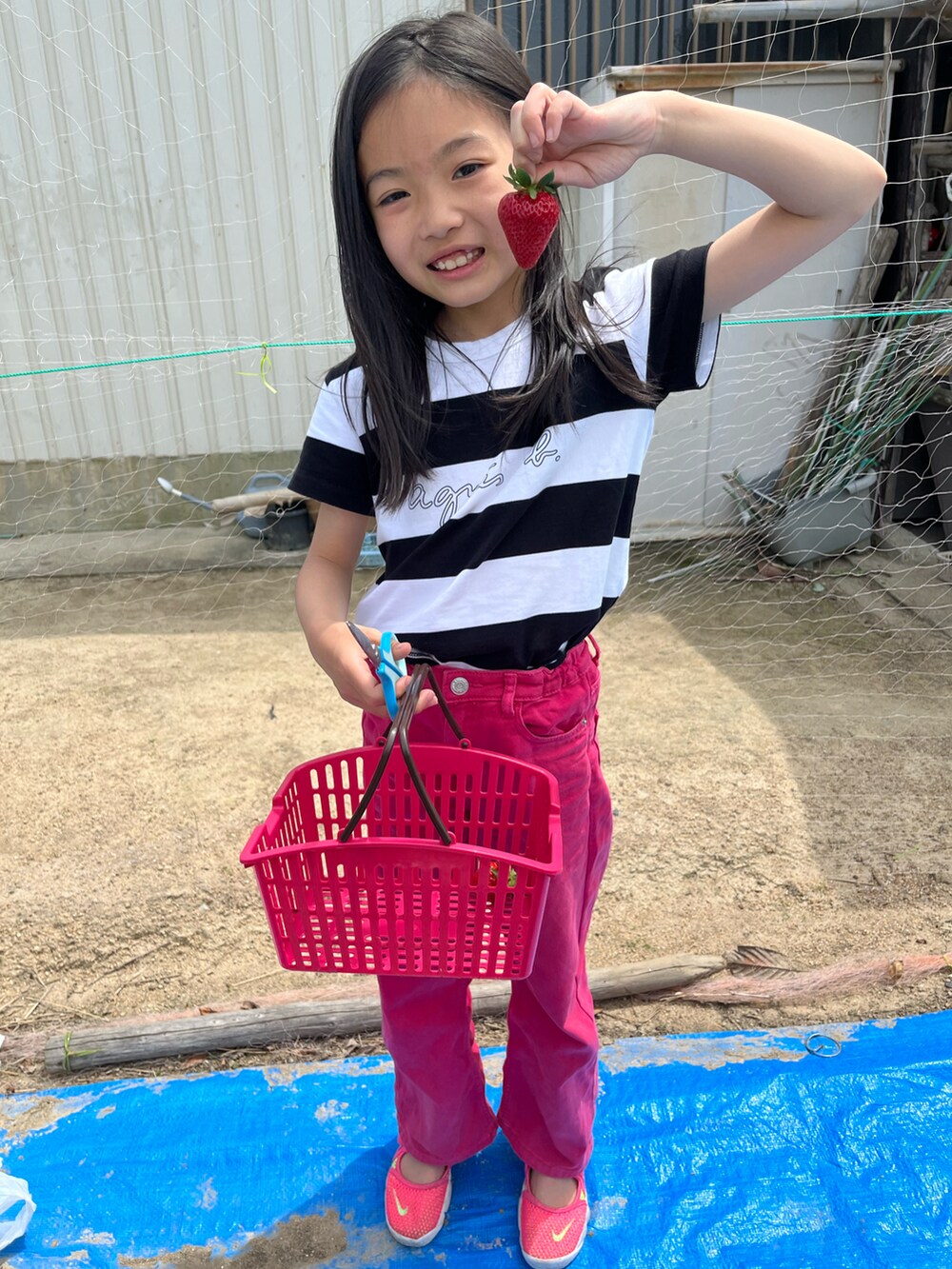 ピンク系のデニムパンツ、ピンク系のスニーカー、ブラック系のTシャツ/カットソーを着用したキッズの春コーディネートの2枚目の写真