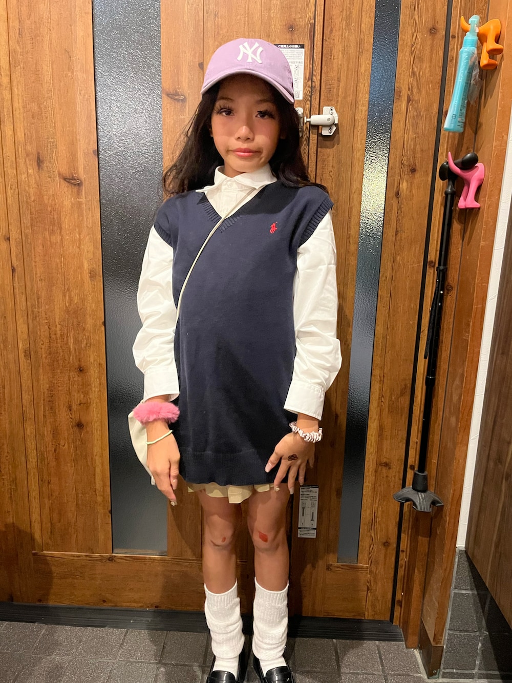 ブラック系のパーカー、ベージュ系のスカート、ブラック系のローファーを着用したキッズの秋コーディネートの2枚目の写真