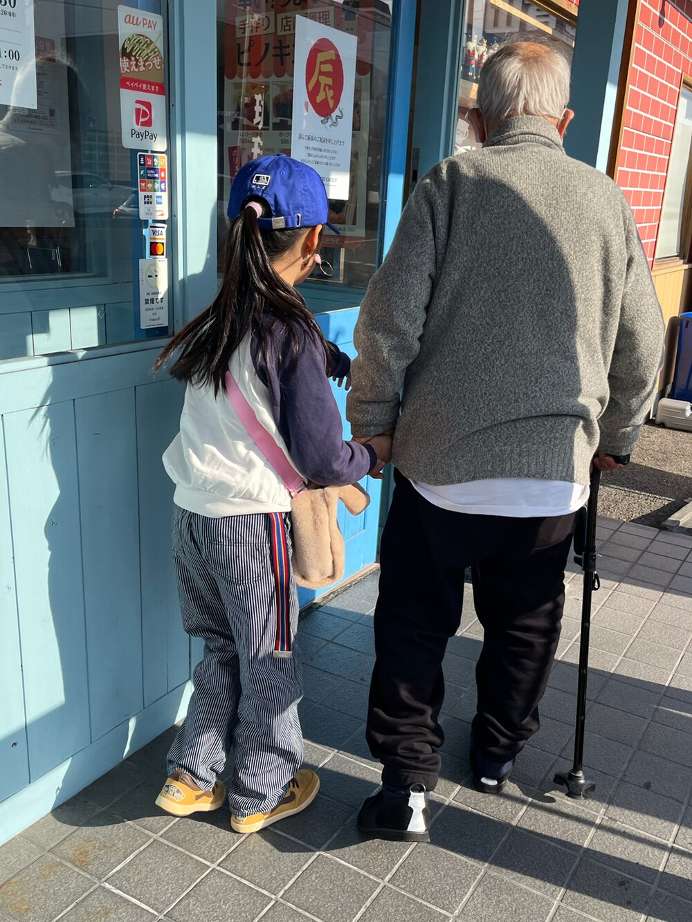 ブルー系のパンツ、ブラウン系のスニーカー、グリーン系のスタジャンを着用したキッズの冬コーディネートの2枚目の写真