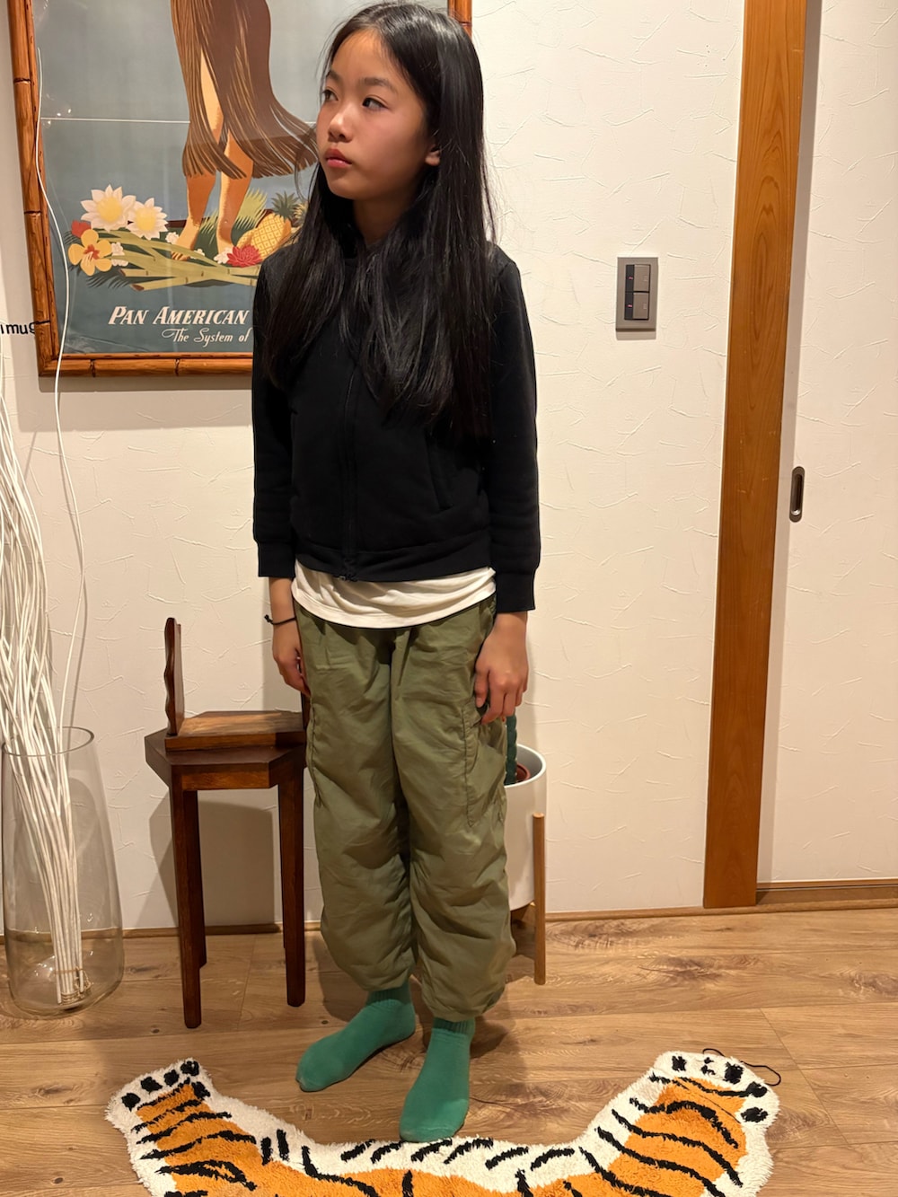 グリーン系のカーゴパンツ、ブラック系のパーカー、ベージュ系のソックス/靴下を着用したキッズの冬コーディネートの2枚目の写真