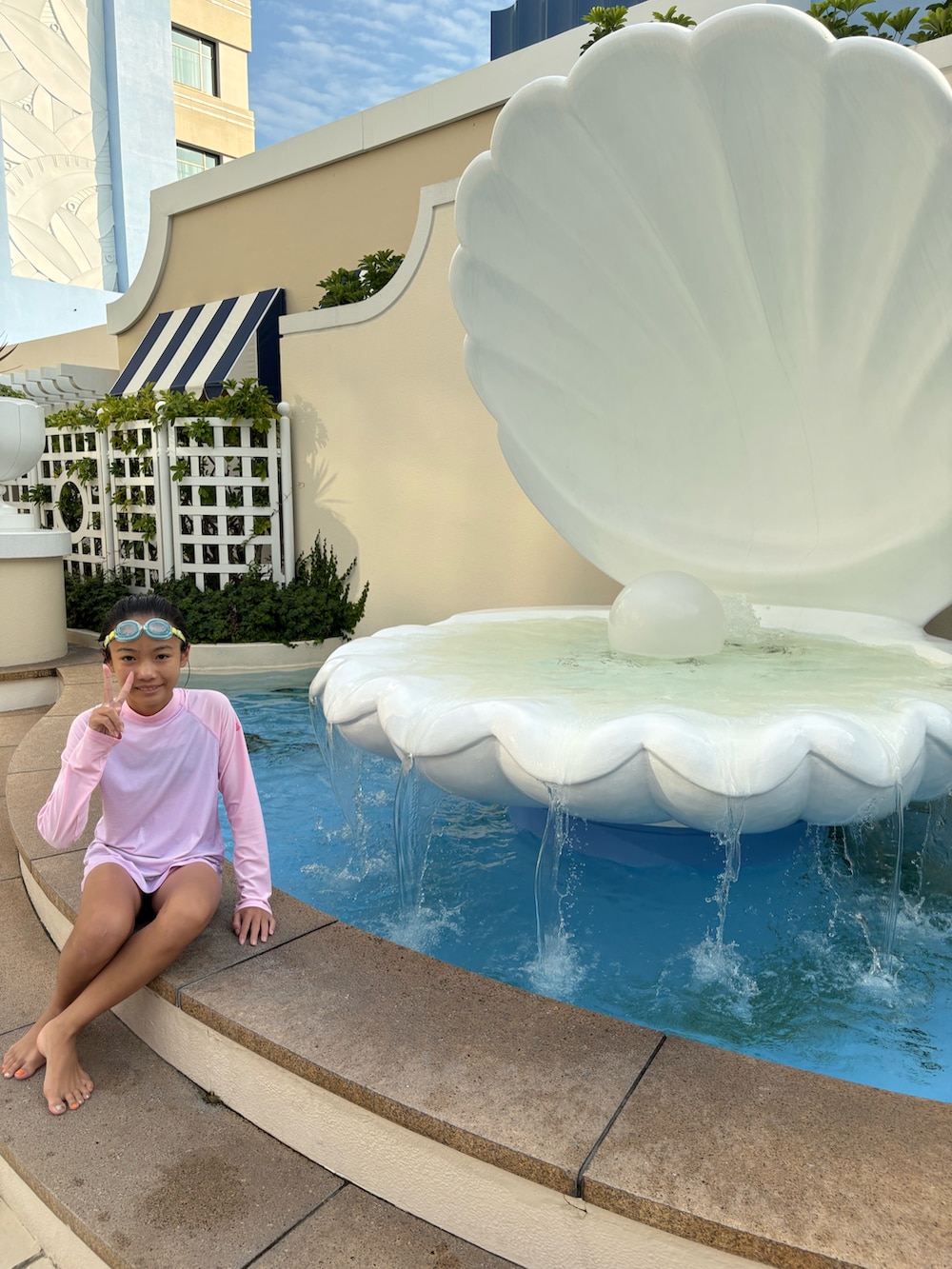 ピンク系のラッシュガード、ブラック系の水着を着用したキッズの夏コーディネートの4枚目の写真