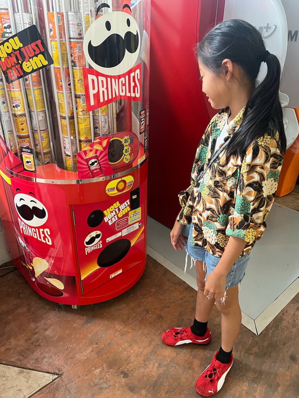 レッド系のスニーカー、ブルー系のデニムパンツ、ブラウン系のシャツ/ブラウスを着用したキッズの秋コーディネートの3枚目の写真