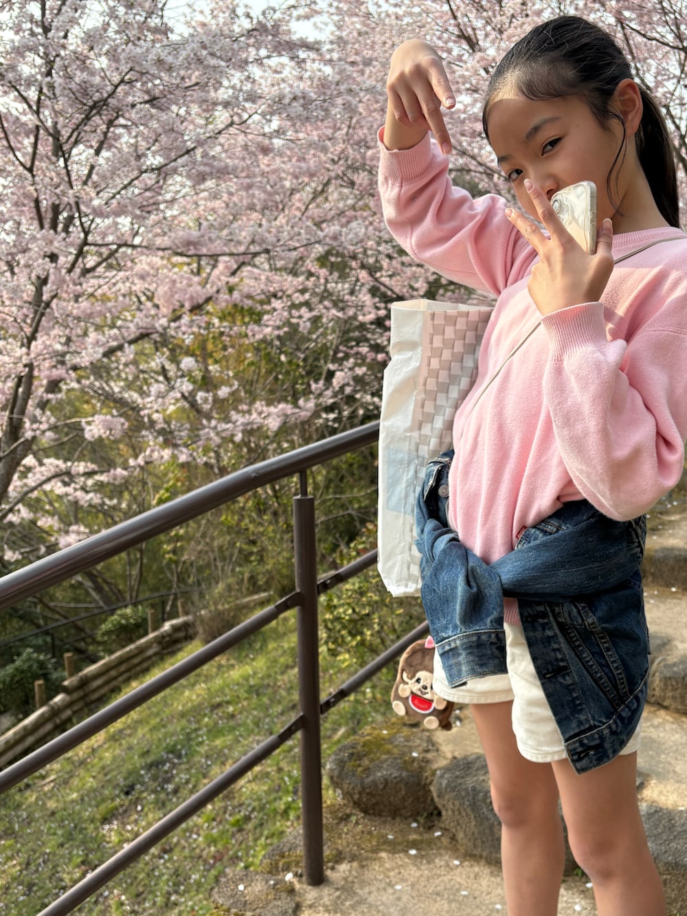 ブルー系のスニーカー、ホワイト系のショルダーバッグ、ホワイト系のデニムパンツを着用したキッズの春コーディネートの2枚目の写真