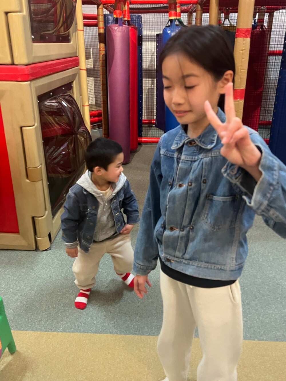 ホワイト系のスウェットパンツ、ブルー系のデニムジャケット、グレー系のパーカーを着用したキッズの冬コーディネートの3枚目の写真