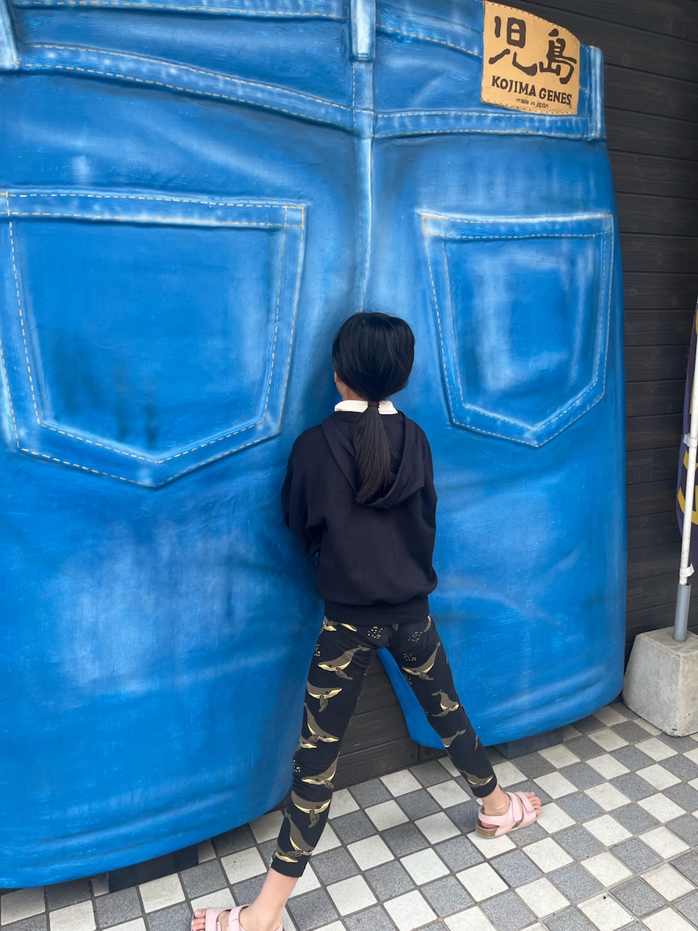 ブラック系のパーカー、ピンク系のサンダル、ブラック系のレギンス/スパッツを着用したキッズの夏コーディネートの2枚目の写真