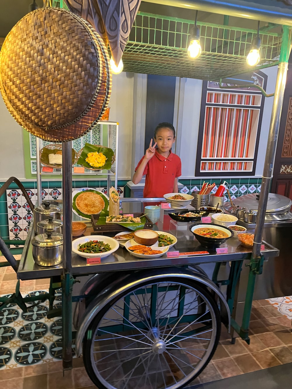 レッド系のポロシャツ、ブルー系のスカート、ピンク系のスニーカーを着用したキッズの夏コーディネートの2枚目の写真