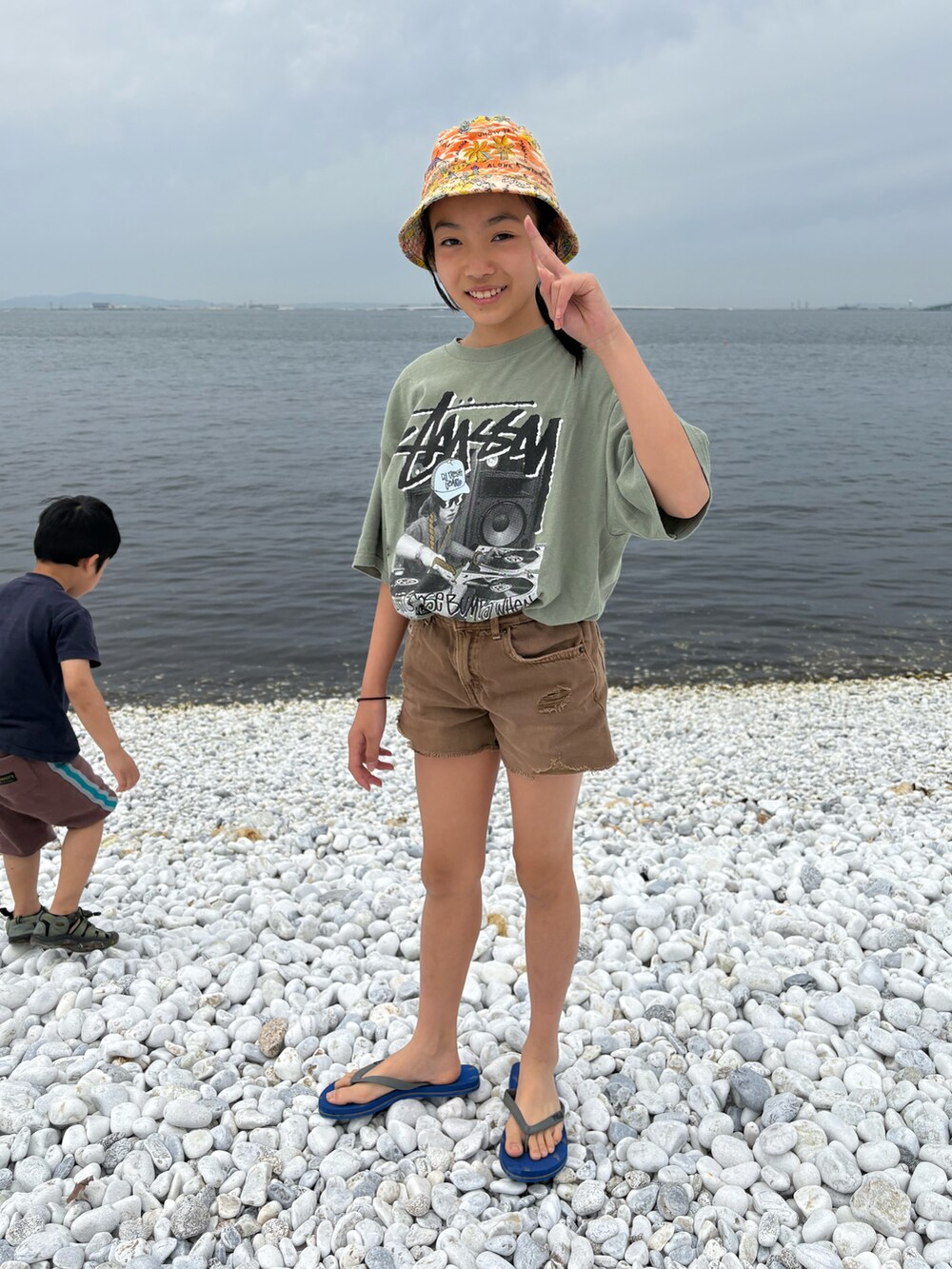ブルー系のスリッポン、ブラウン系のその他パンツ、グリーン系のTシャツ/カットソーを着用したキッズの春コーディネートの2枚目の写真