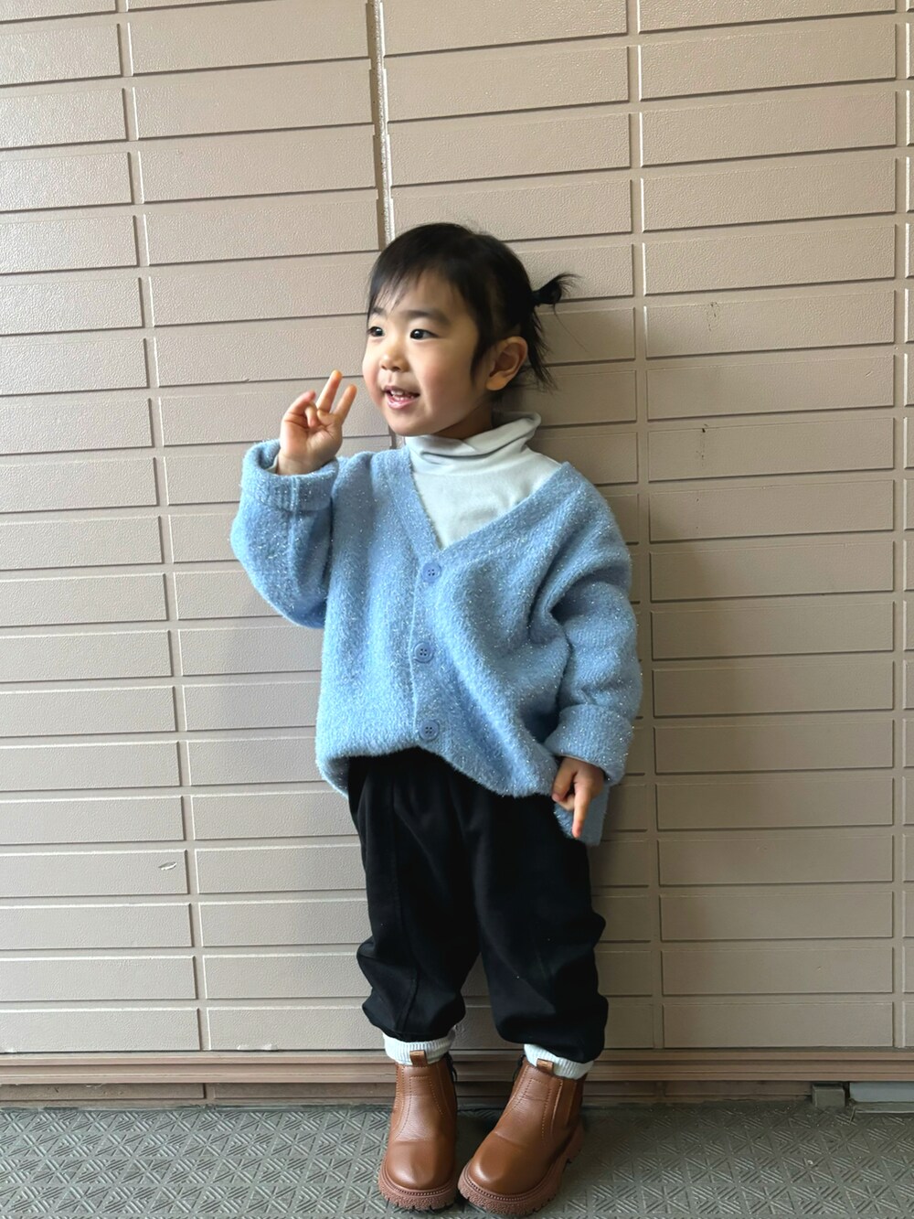 ブルー系のカーディガン/ボレロ、ブラック系のスウェットパンツ、ブラウン系のブーツを着用したキッズの冬コーディネートの2枚目の写真