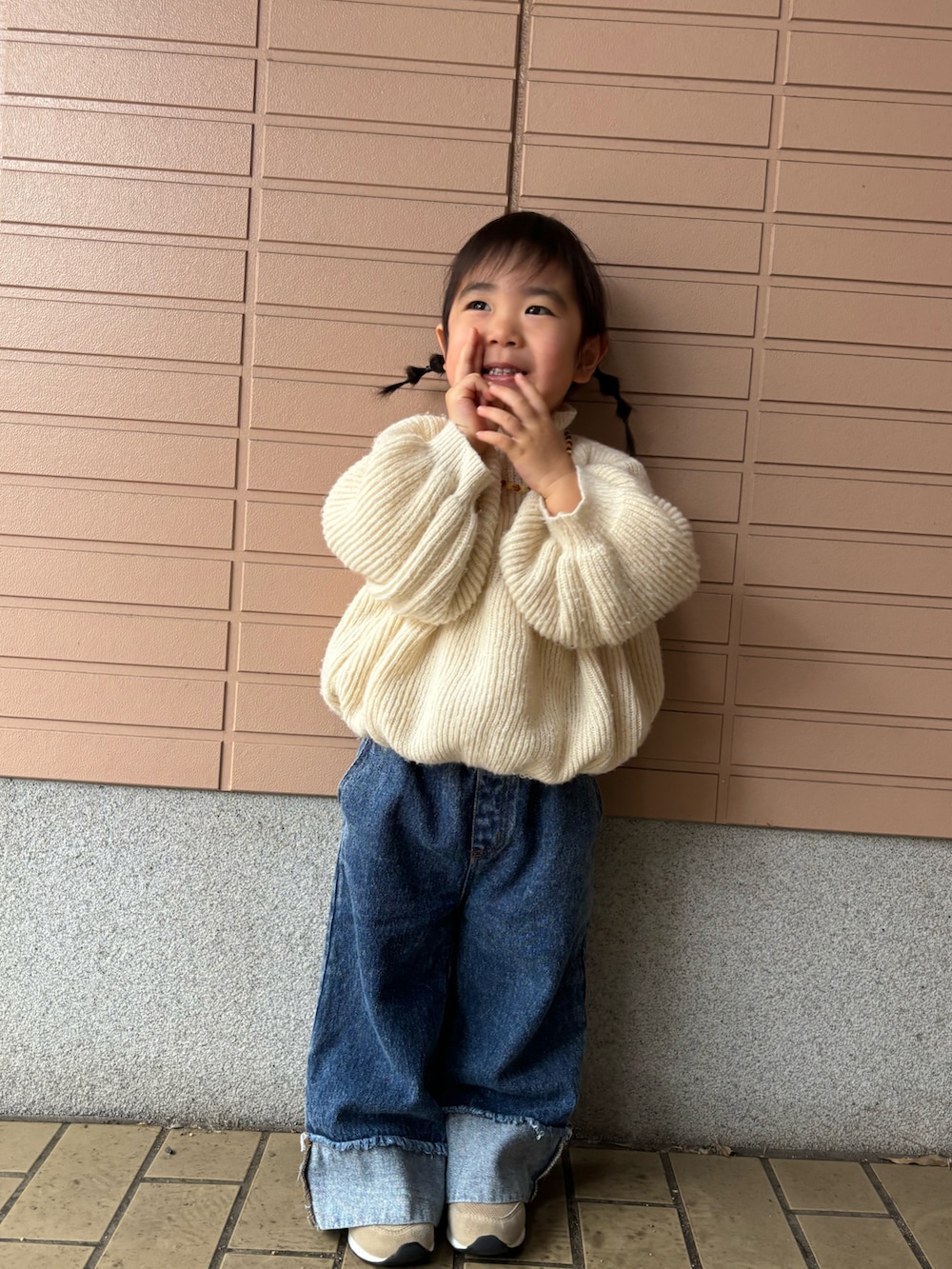 ホワイト系のニット/セーター、ブルー系のデニムパンツ、ベージュ系のスニーカーを着用したキッズの冬コーディネートの2枚目の写真