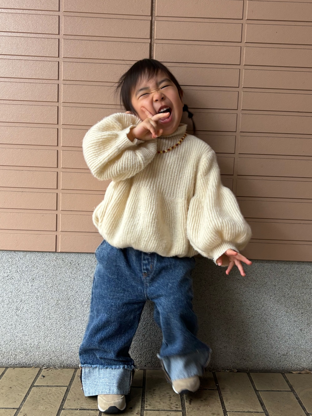 ホワイト系のニット/セーター、ブルー系のデニムパンツ、ベージュ系のスニーカーを着用したキッズの冬コーディネートの3枚目の写真