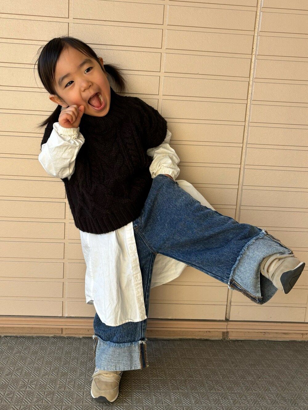 ブラック系のベスト、ホワイト系のシャツ/ブラウス、ブルー系のデニムパンツを着用したキッズの冬コーディネートの3枚目の写真