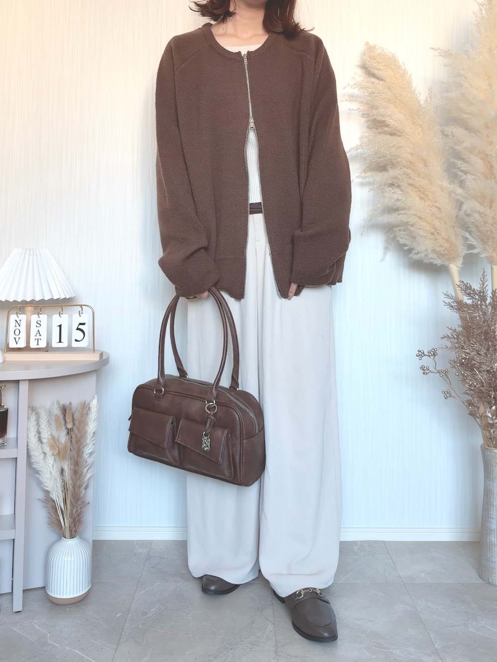 ブラウン系のショルダーバッグを着用したレディースの秋コーディネートの3枚目の写真