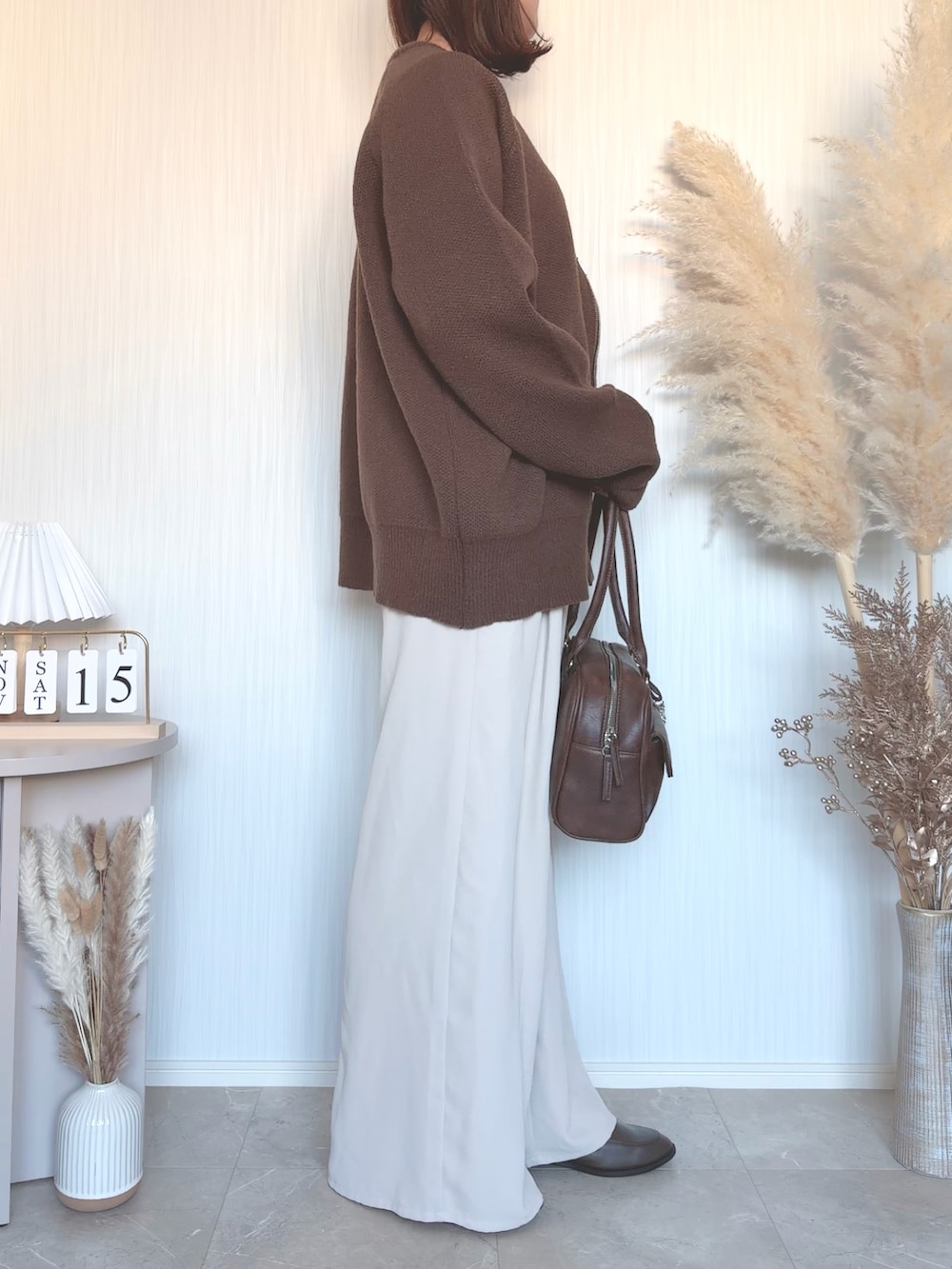 ブラウン系のショルダーバッグを着用したレディースの秋コーディネートの4枚目の写真