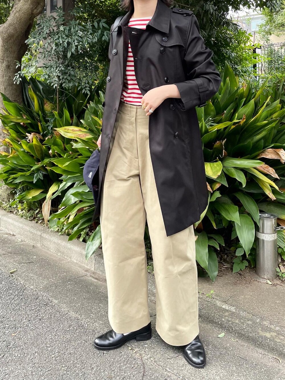 ベージュ系のその他パンツ、ブラック系のトレンチコートを着用したレディースの秋コーディネートの2枚目の写真