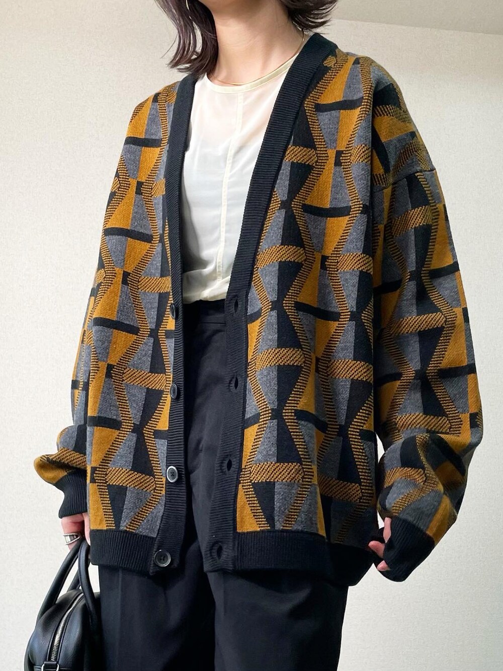 ブラック系のブーツ、イエロー系のカーディガン/ボレロ、ブラック系のその他パンツを着用したレディースの秋コーディネートの4枚目の写真