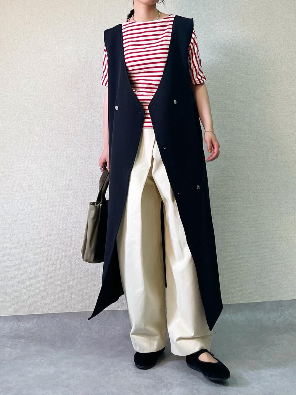 ブラック系のジャンパースカート、ホワイト系のその他パンツを着用したレディースの夏コーディネートの2枚目の写真