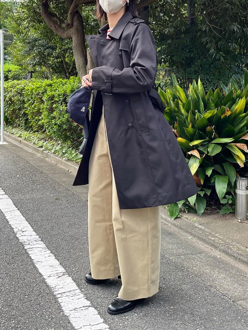 ベージュ系のその他パンツ、ブラック系のトレンチコートを着用したレディースの秋コーディネートの4枚目の写真