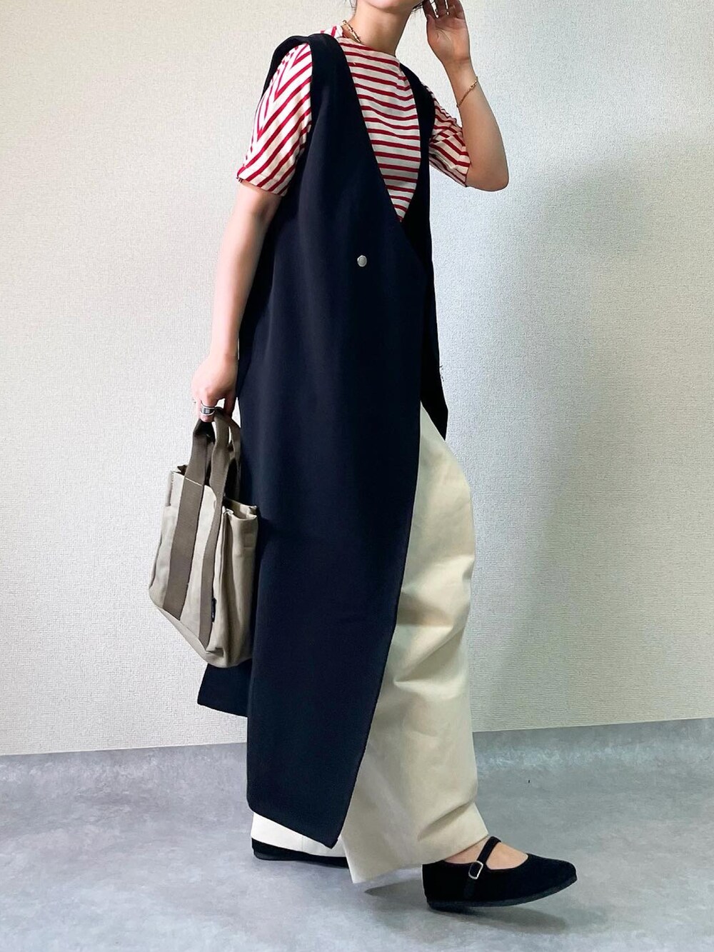 ブラック系のジャンパースカート、ホワイト系のその他パンツを着用したレディースの夏コーディネートの3枚目の写真