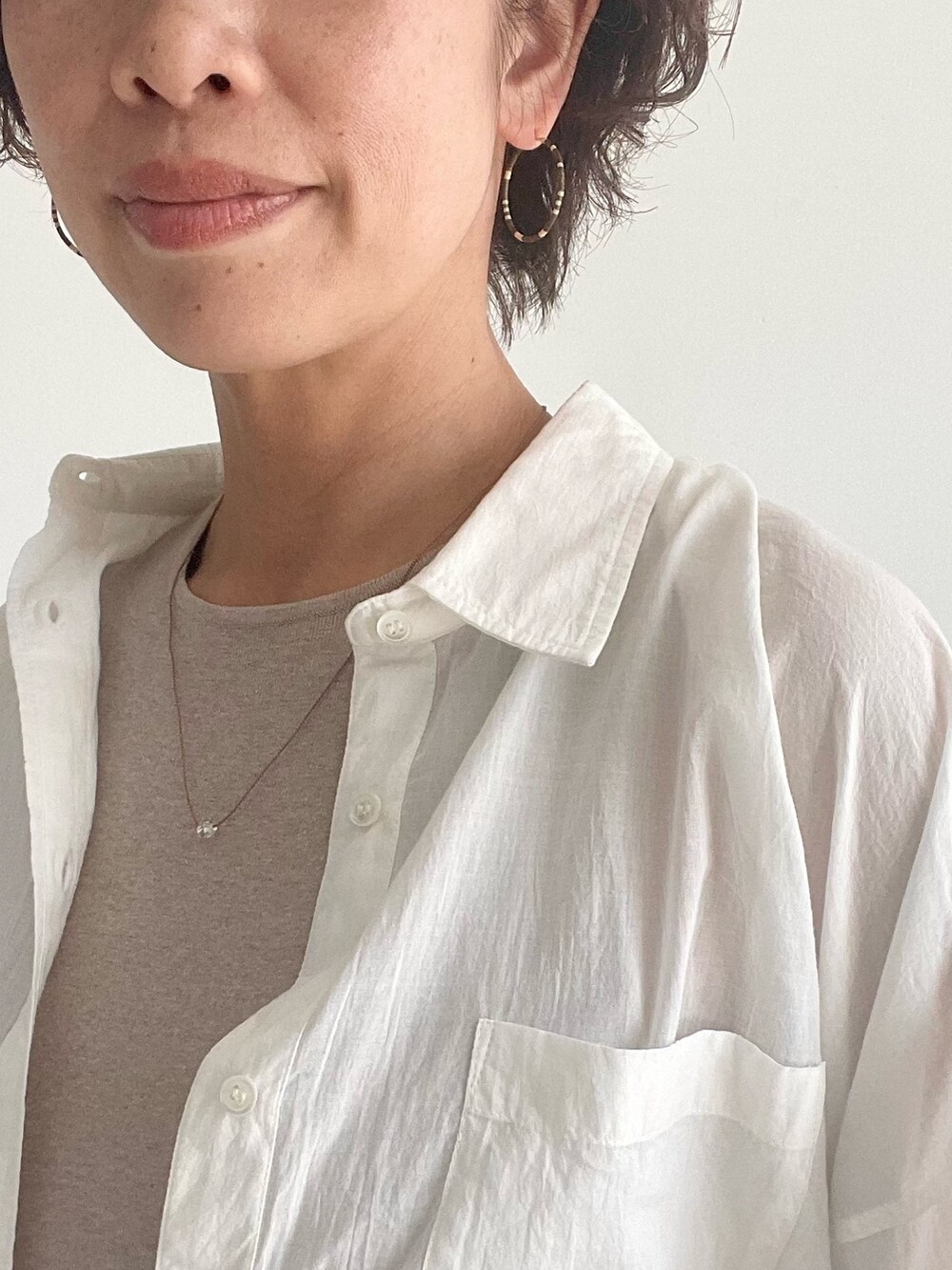 ホワイト系のシャツ/ブラウス、ベージュ系のワンピースを着用したレディースの春コーディネートの3枚目の写真