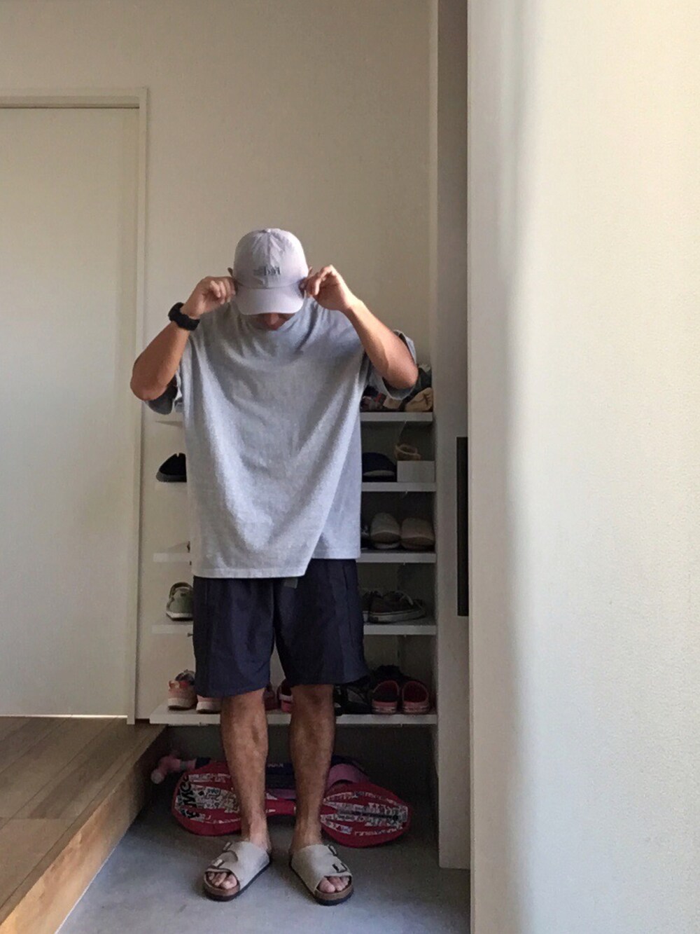 グレー系のTシャツ/カットソー、グレー系のサンダル、ブルー系のカーゴパンツを着用したメンズの夏コーディネートの2枚目の写真
