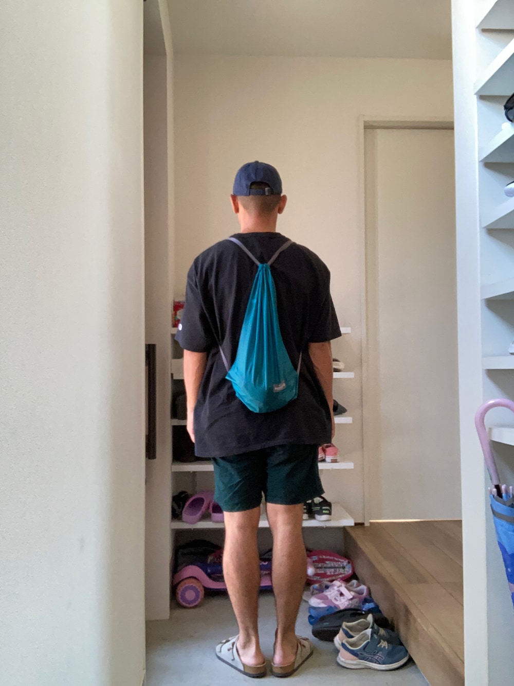 ブラック系のTシャツ/カットソー、グリーン系のその他パンツ、ブルー系のバッグを着用したメンズの夏コーディネートの2枚目の写真