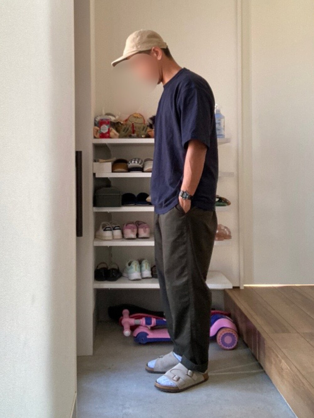 グリーン系のチノパンツ、ブルー系のTシャツ/カットソー、グレー系のサンダルを着用したメンズの秋コーディネートの2枚目の写真