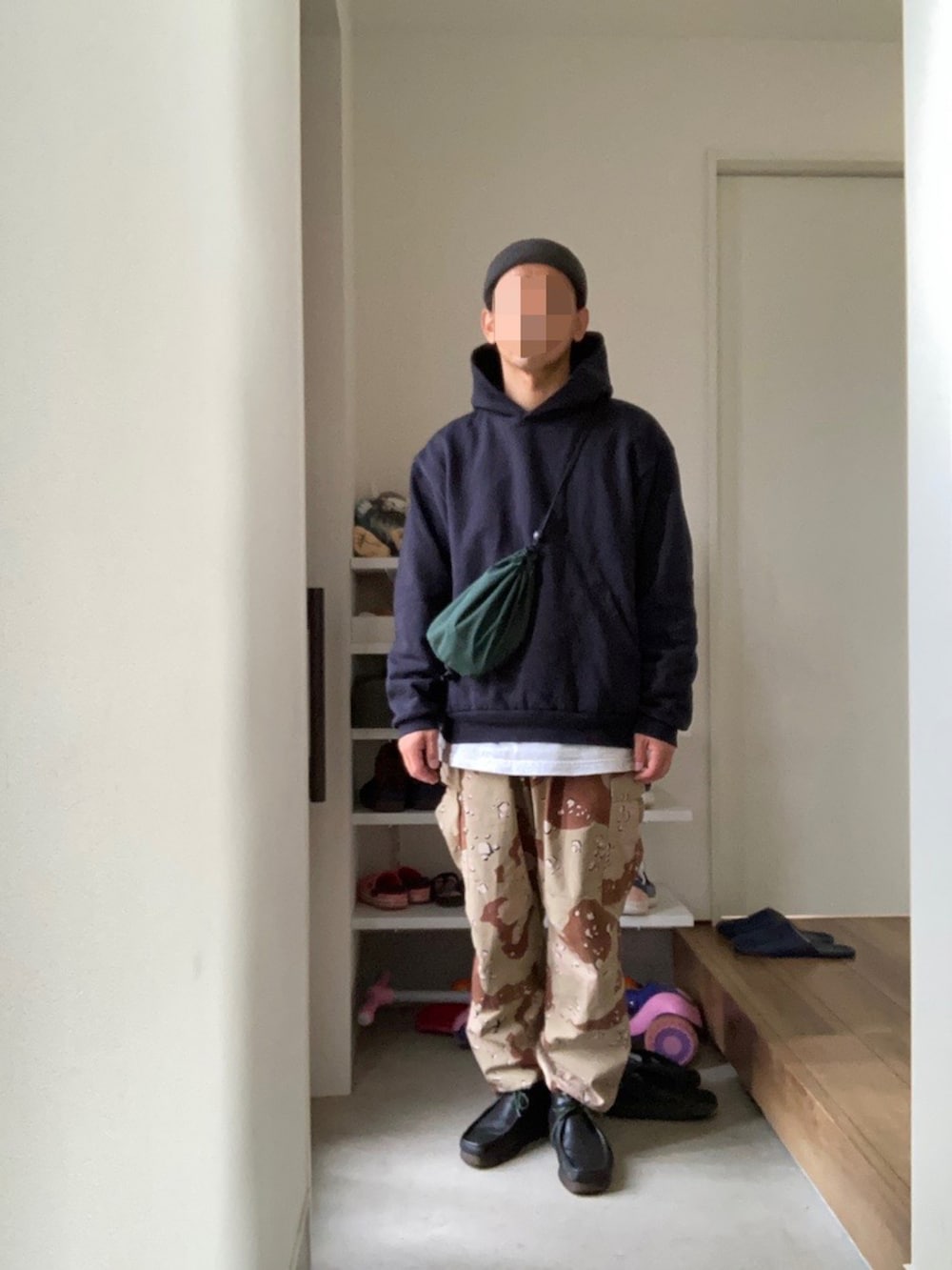 ブルー系のパーカー、グリーン系のバッグ、ベージュ系のカーゴパンツを着用したメンズの春コーディネートの2枚目の写真