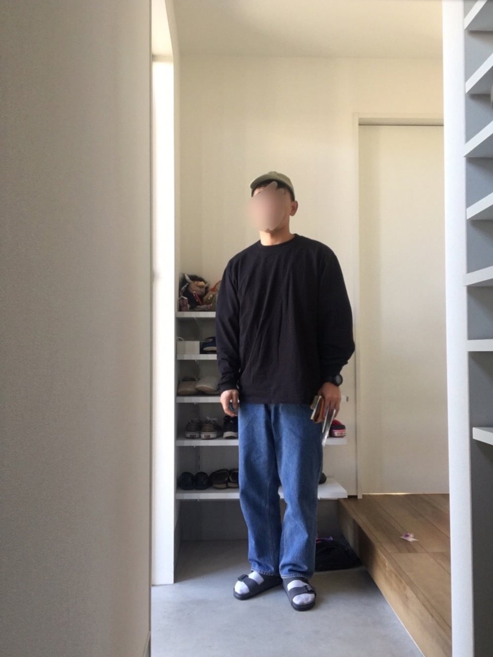 ブラック系のTシャツ/カットソー、ブルー系のデニムパンツ、グレー系のサンダルを着用したメンズの秋コーディネートの2枚目の写真