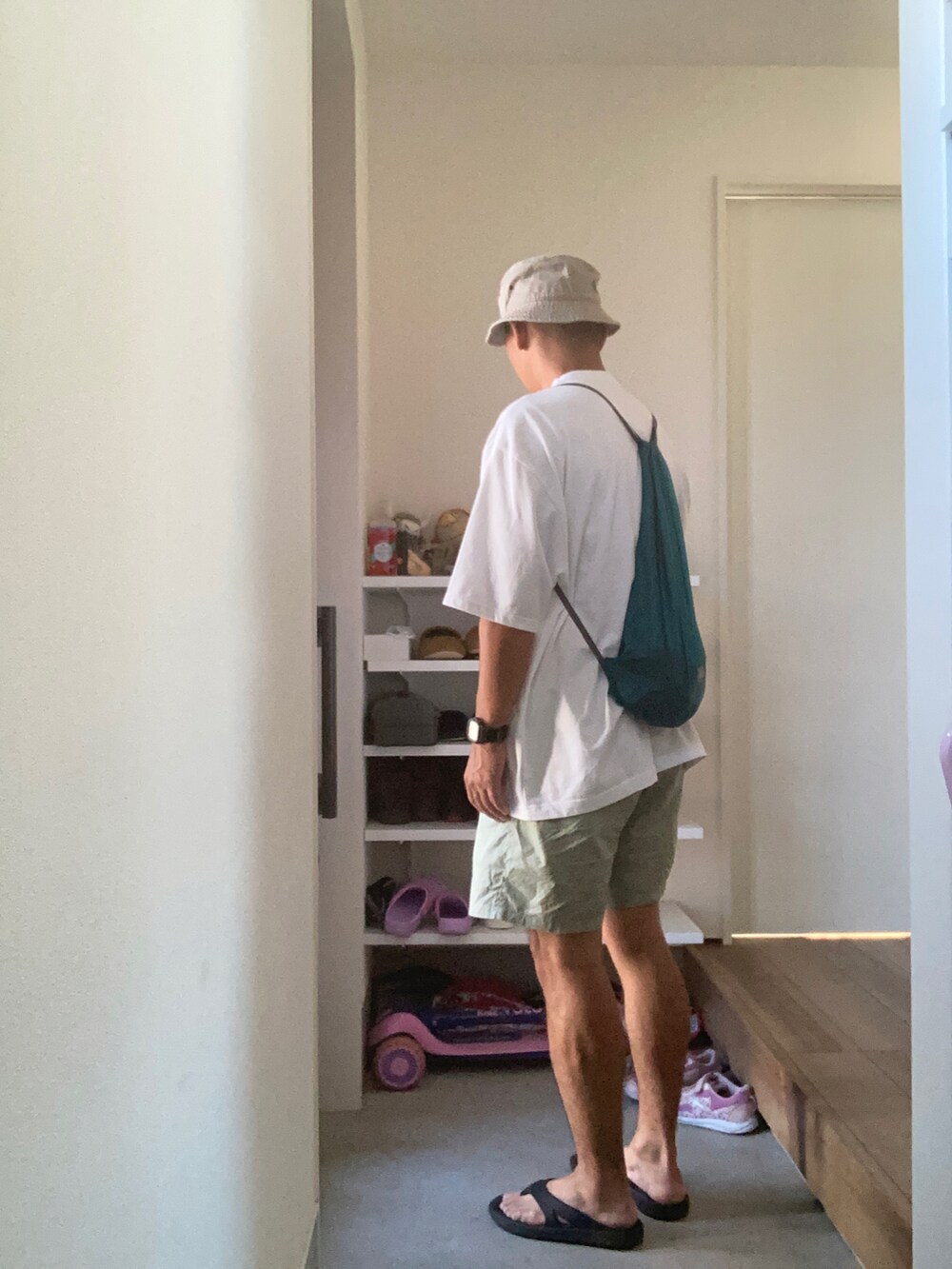 ホワイト系のTシャツ/カットソー、グリーン系のその他パンツ、ブラック系のサンダルを着用したメンズの夏コーディネートの2枚目の写真