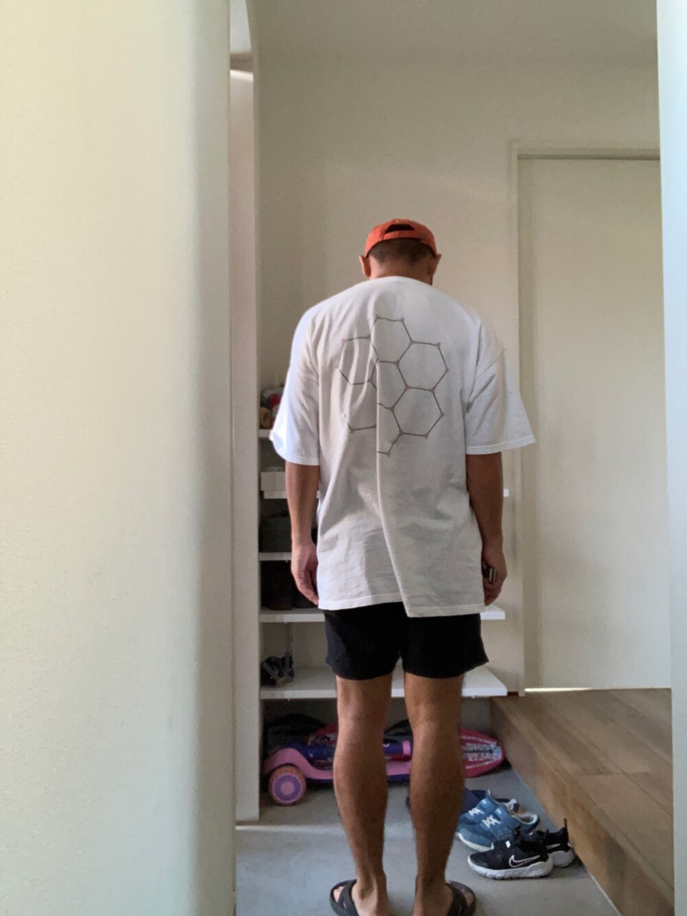 ホワイト系のTシャツ/カットソー、ブラック系のその他パンツ、ブラック系のサンダルを着用したメンズの夏コーディネートの2枚目の写真