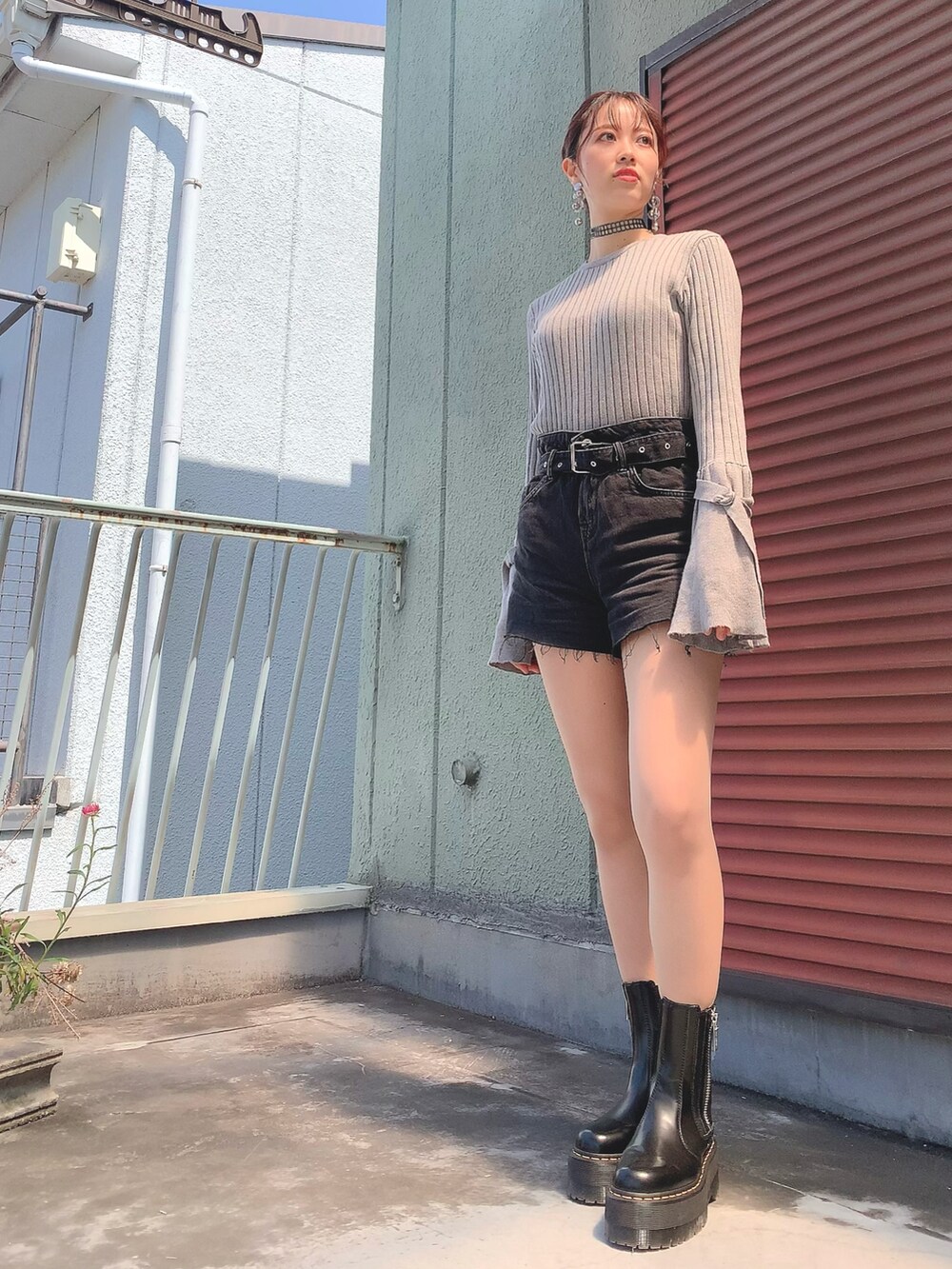 ブラック系のデニムパンツ、ブラック系のブーツ、ホワイト系のデニムジャケットを着用したレディースの春コーディネートの2枚目の写真