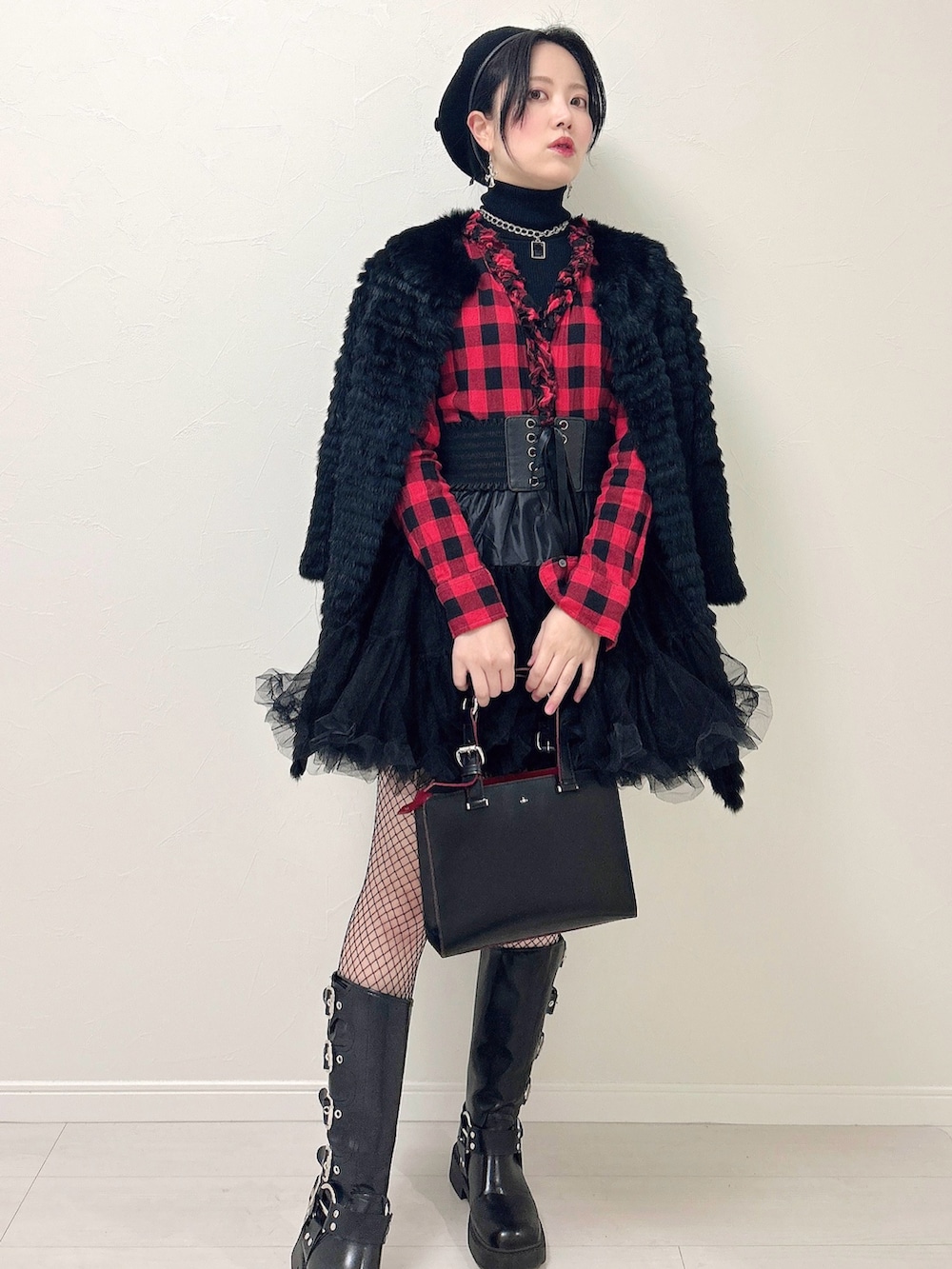 ブラック系のニット/セーター、レッド系のシャツ/ブラウス、ブラック系のスカートを着用したレディースの冬コーディネートの3枚目の写真